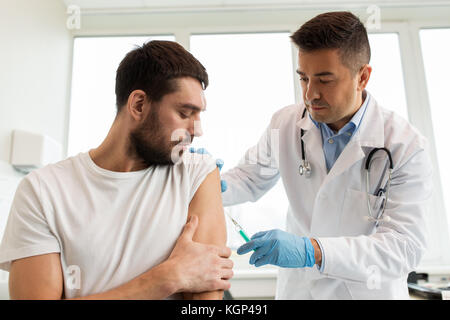 Patient und Arzt mit Spritze tun Impfung Stockfoto