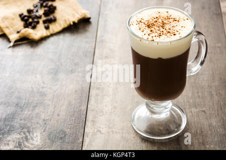 Irish Coffee in Glas auf hölzernen Tisch Stockfoto