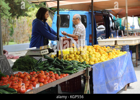 Vouliagmeni Griechenland Samstag Marktstand Inhaber Verkauf von Zitronen, Gurken, Tomaten Stockfoto