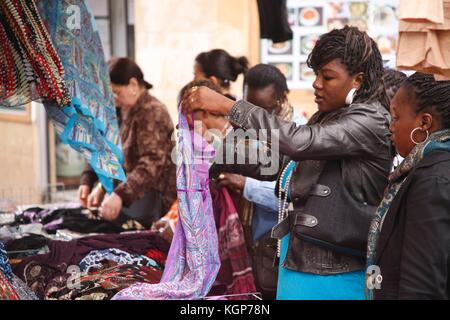 Die französischen Frauen afrikanischer Herkunft auf Durchsuchen, um einen Markt im Quartier Belleville Abschaltdruck Stockfoto