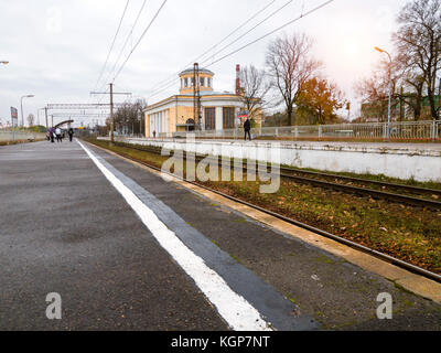 Bahnhof Krassnoje Selo im Herbst. asphaltierte Passagier Plattform, die für die Aufbringung einer S-Bahn rzd. Verkehrsinfrastruktur - Schiene und hohe Spannung Stockfoto