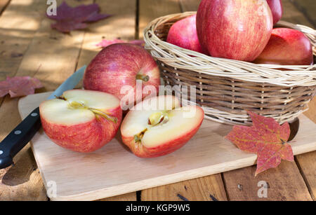 In Scheiben geschnitten Apple mit anderen ganze Äpfel auf einer hölzernen Oberfläche Stockfoto