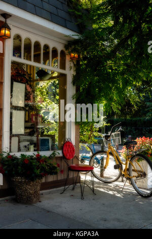 Detail eines altmodischen Storefront oder Restaurant. Fahrräder und roten Stuhl vor Stockfoto