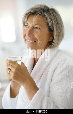 Ältere Frau im Bademantel trinken heißen Grüner Tee Stockfoto