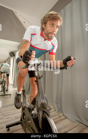 Junge schöne bestimmt man die Ausbildung in einem Radfahren Fitnessstudio. Stockfoto