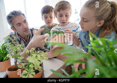 Lehrer mit Kindern im Biologieunterricht lernen über Pflanzen Stockfoto