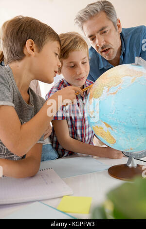 Lehrer mit Kindern in Geographie Klasse suchen bei Globe Stockfoto