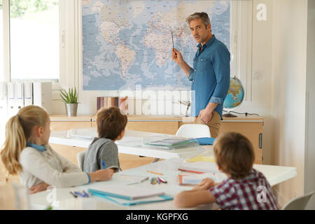Lehrer im Klassenzimmer, Kinder an Geographie Lektion Stockfoto