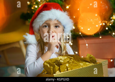 Portrait von niedlichen kleinen Mädchen halten ein Geheimnis am Heiligabend Stockfoto