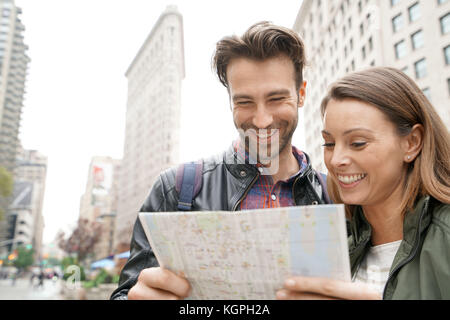 Paar in new york city an touristische Karte Suchen von Flatiron Stockfoto