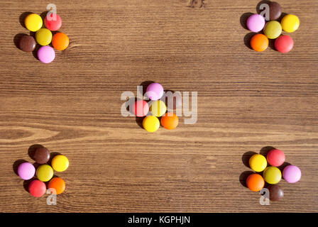 Blume - von bunten Süßigkeiten für Hintergründen auf thewooden Tabelle geformt Stockfoto