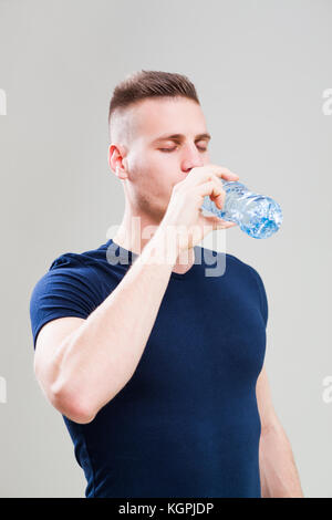 Studio shot Bild junger sportlicher Mann, trinken Wasser ist. Stockfoto