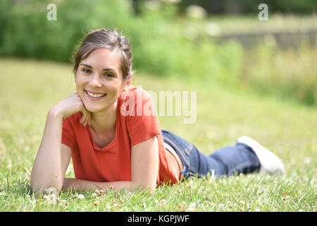 Portrait von fröhliche junge Frau Festlegung im Gras Stockfoto