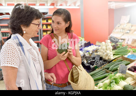 Ältere Frau, Lebensmittelgeschäft mit Hilfe der Pflegeperson Stockfoto