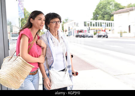 Ältere Frau mit nach Hause Pflegeperson Warten auf den Bus Stockfoto