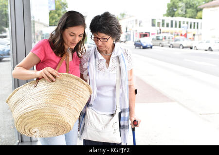 Ältere Frau mit nach Hause Pflegeperson Warten auf den Bus Stockfoto