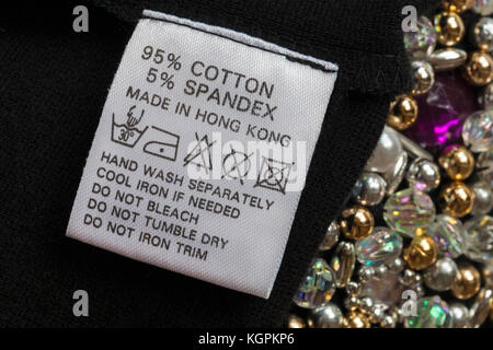 95% Baumwolle 5% Elasthan Label in der Frau kleine schwarze Kleid mit Perlen in Hong Kong mit Waschen pflege Symbole und Anweisungen Stockfoto
