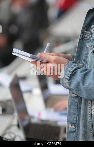 Jemand schreibt in seinem noticebook Stockfoto