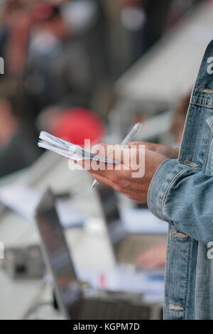 Jemand schreibt in seinem noticebook Stockfoto