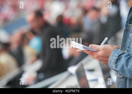 Jemand schreibt in seinem noticebook Stockfoto