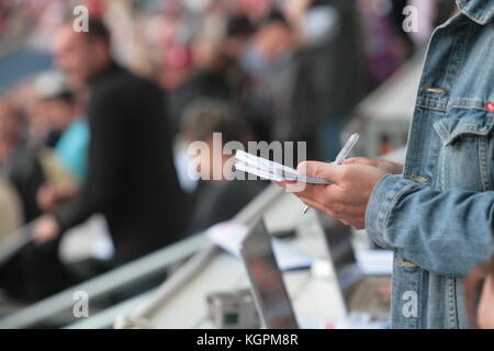 Jemand schreibt in seinem noticebook Stockfoto