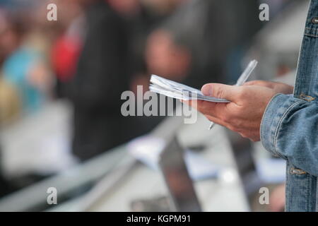 Jemand schreibt in seinem noticebook Stockfoto