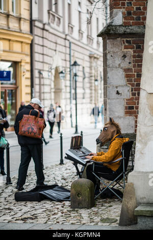 Straßenmusiker mit Pferd Maske Klavier spielen, Krakau, Polen, Europa. Stockfoto