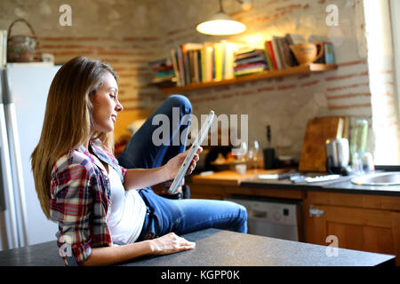 Hipster Mädchen surfen auf Tablet in der Küche Stockfoto