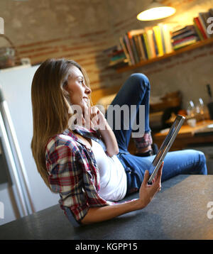 Hipster Mädchen surfen auf Tablet in der Küche Stockfoto