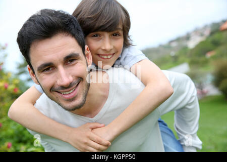 Vater piggyback Ride an seinen Sohn Stockfoto