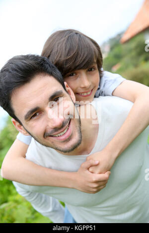 Vater piggyback Ride an seinen Sohn Stockfoto