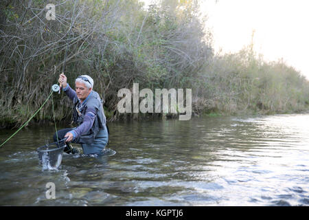 Fliegenfischer Fang von Forellen in Kescher Stockfoto