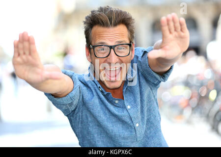 Fröhlicher Kerl mit Brille, hands up Stockfoto