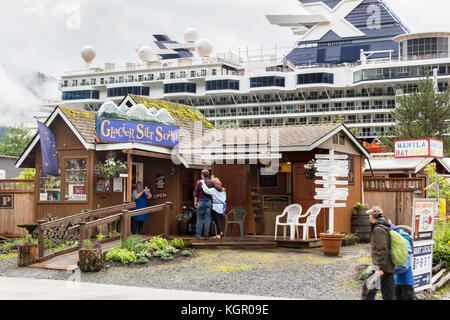 Juneau, Alaska, USA - 28. Juli 2017: Mitarbeiter der Gletscher schlick Seife shop sind die Fotos mit einem mobilen außerhalb des Speichers in einer regnerischen Tag. Stockfoto