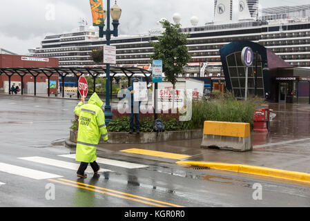 Juneau, Alaska, USA - 28. Juli 2017: Crossing Guard mit dem STOP-Schild auf seiner Hand am Cruise Terminal arbeiten in janeau. Stockfoto