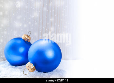 Zwei Weihnachten Spielzeug blauen Kugeln im Schnee liegend auf hölzernen weißen Hintergrund und Kopie sind. Stockfoto