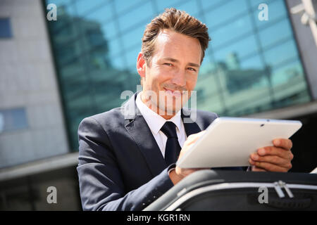 Geschäftsmann draußen Sitzen im Büro und auf Tablet Stockfoto