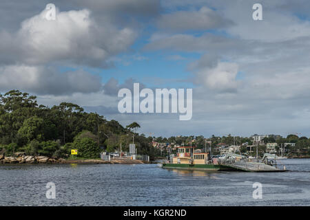 Parramatta, Australien - März 24, 2017: grün-gelb mortlake Fähre überquert Parramatta River Transport von Autos und Menschen. Häuser und grüne Vegetation Stockfoto