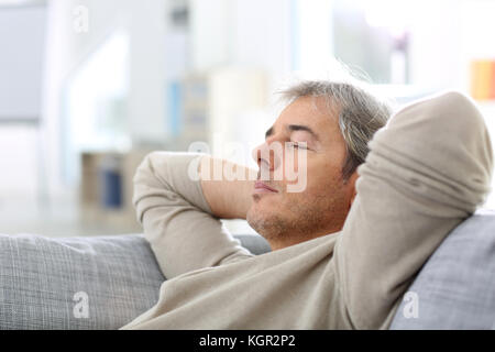 Mann ein Nickerchen im Sofa bei Thome Stockfoto