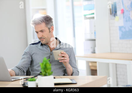 Entspannt man von zu Hause auf dem Laptop Stockfoto