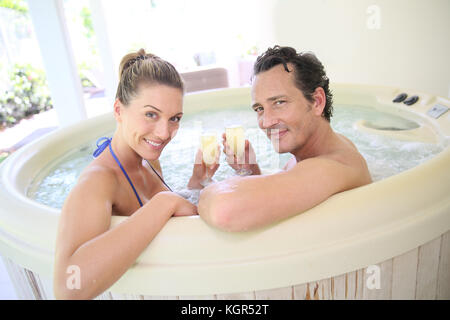 Romantisches Paar trinken cahmpagne im Whirlpool Stockfoto