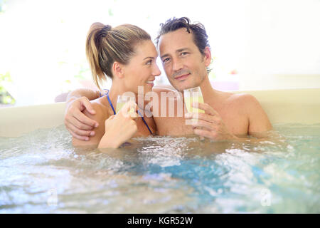 Romantisches Paar trinken cahmpagne im Whirlpool Stockfoto