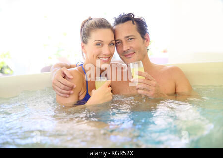 Romantisches Paar trinken cahmpagne im Whirlpool Stockfoto