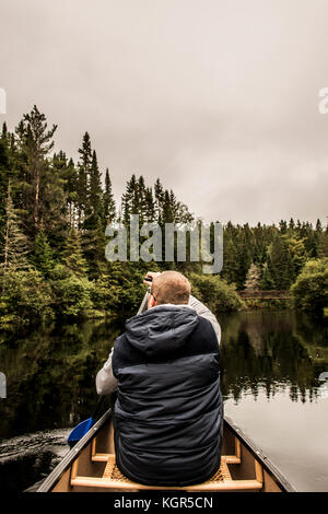 Man Kanu fahren mit dem Kanu auf dem See der beiden Flüsse in den algonquin National Park in Ontario Kanada an einem bewölkten Tag