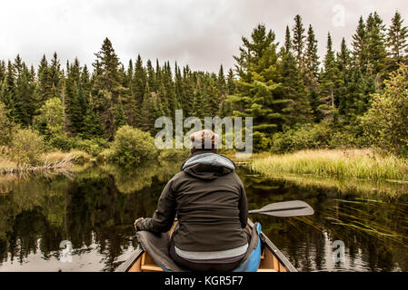 Mädchen Kanu fahren mit dem Kanu auf dem See der beiden Flüsse in den algonquin National Park in Ontario Kanada an einem bewölkten Tag