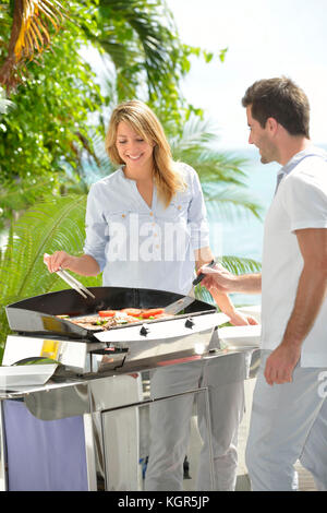 Freundliche paar Zubereitung Gegrilltes auf Grill Stockfoto