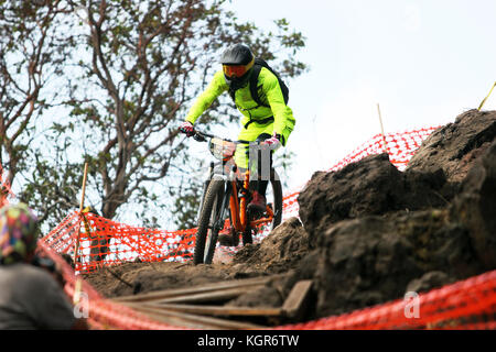 Enduro Biker mit leuchtend gelben Kostüm bergab auf einem Rock Garden Stockfoto