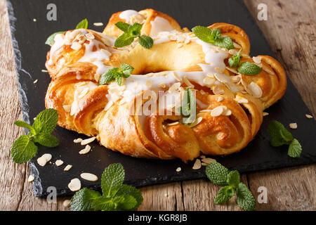 Weihnachten brioche Kuchen mit Mandeln, mit frischer Minze Nahaufnahme auf dem Tisch dekoriert. Horizontale Stockfoto