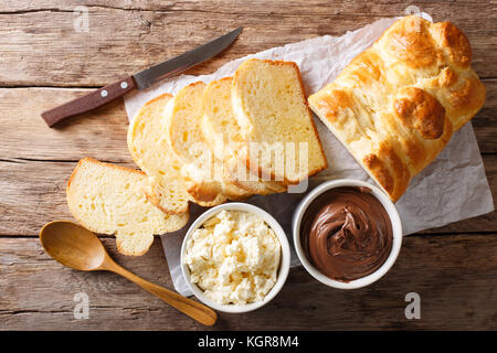 Frisch Brioche Brot und Rahm Käse, Schokolade auf dem Tisch. horizontal oben Ansicht von oben Stockfoto