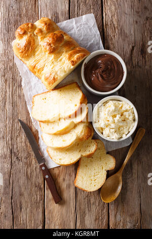 Frisch Brioche Brot und Rahm Käse, Schokolade auf dem Tisch. Senkrechte Draufsicht von oben Stockfoto